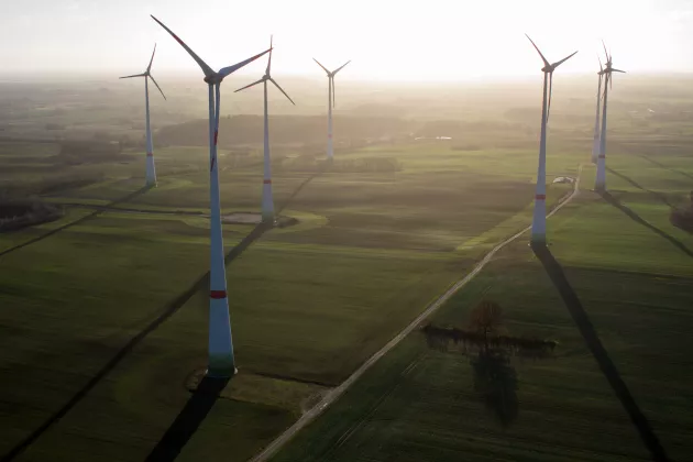 Sechs Windkraftanlagen auf Feldern aus der Vogelperspektive.