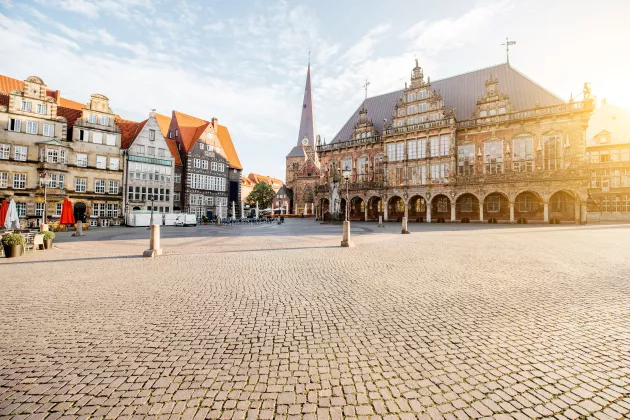 Blick auf den Marktplatz mit Rathaus, alter Kirche und schönen Gebäuden bei Morgenlicht in Bremen, Deutschland.