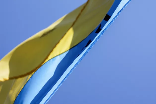 Eine Ukrainische Flagge, die vor blauem Himmel weht.