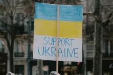 Ein Demo-Plakat in blau und gelb auf dem steht: Support Ukraine.