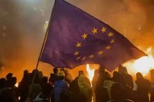 Menschliche Umrisse for brennendem Hintergrund, Flagge der EU im Vordergrund 