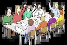 Mehrere Menschen sitzen an einem Tisch und machen eine Abstimmung. Manche haben die Hände gehoben, manche nicht.