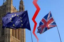 EU-Flagge und Großbritannien-Flagge vor blauem Himmel und dem Palace of Westminster