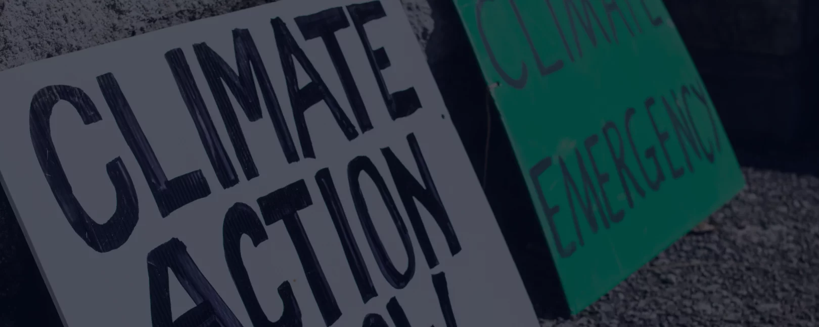 Ein dekoratives Foto von zwei Klima-Demo-Plakaten, auf denen steht 