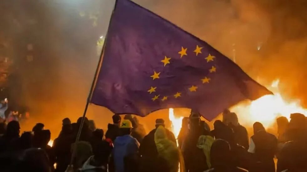 Brennende Barrikaden von Tblissi Menschliche Umrisse for brennendem Hintergrund, Flagge der EU im Vordergrund