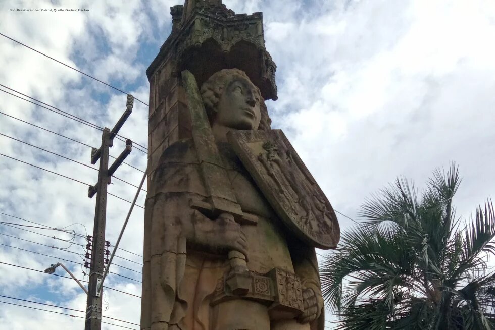 Eine Statur des bremischen Rolands in Brasilien, im Hintergrund sind Palmen zu sehen.