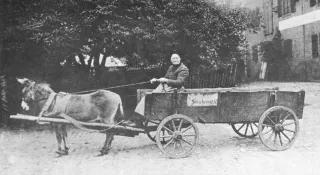 Schwarz Weiß Fotografie von Mutter Cordes um 1890 auf einer Kutsche sitzend.